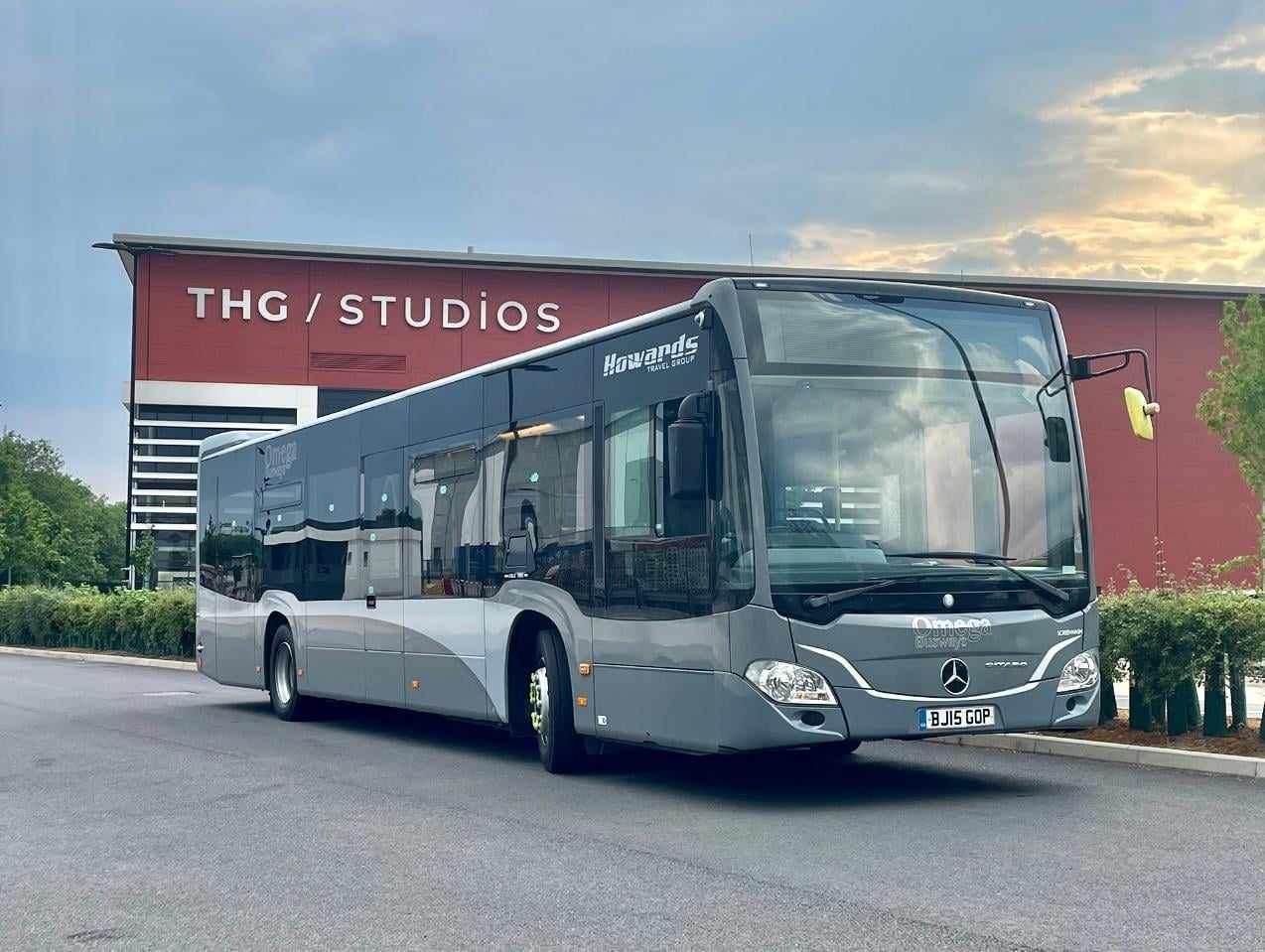 An Omega Busways single decker bus in front of The Hut Group offices in Manchester, UK.